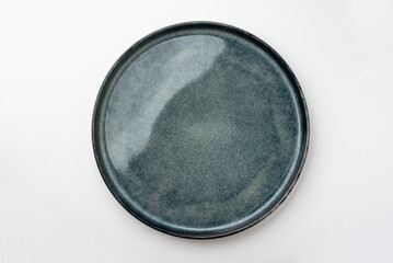 An empty textured plate on a white table