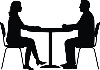 Silhouette of two people seated at a round table in a business conversation or meeting

