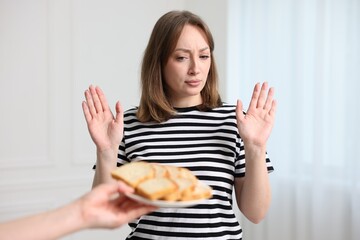 Gluten free diet. Woman refusing from bread indoors