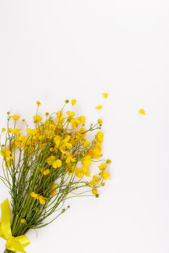 Vertical photo of yellow wildflower bouquet with buttercups and herbs, bright flat lay for summer solstice, midsummer celebration, nature rituals, healing plants and folk traditions