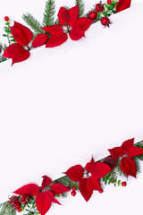 Christmas decoration. Flowers of red poinsettia, branch christmas tree, red berries with space for text on a white background. Top view, flat lay