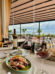 Restaurant by the sea with outdoor terrace, lunch by the sea, beautiful serving and serving with...