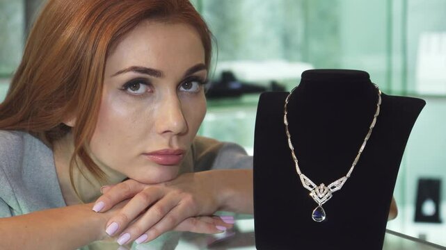 Sad woman posing with an expensive diamond necklace at the store