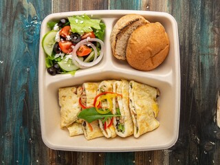 Cheese Omelette Meal with Potato Wedges and Bread Roll in Eco-Friendly Tray – Top View