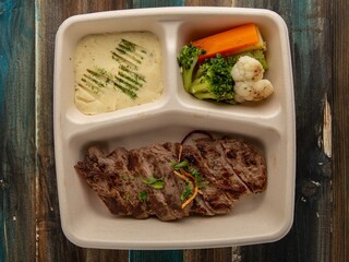 Cheese Omelette Meal with Potato Wedges and Bread Roll in Eco-Friendly Tray – Top View