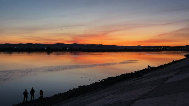 sunset over the river. people on the riverbank embankment