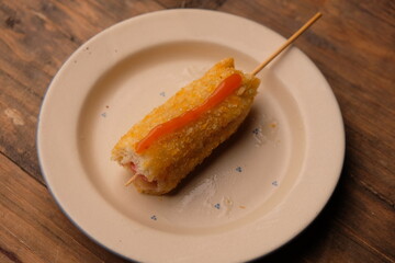 A corn dog is a hot dog on a stick that has been coated in a thick layer of cornmeal batter and deep fried