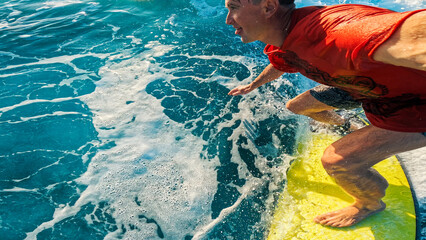 Person in red shirt surfs the wave in the tropics