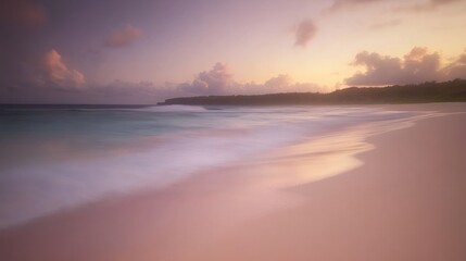 Fototapeta premium Gentle waves on a pink-toned beach at sunset.