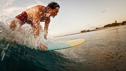 Male surfer takes off and starts riding the wave and falls