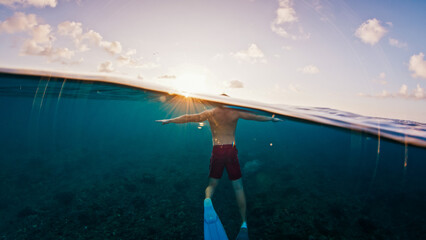 Man swims in the sea with breaking waves. Splitted shot of the male swimming in the ocean on a surfing spot