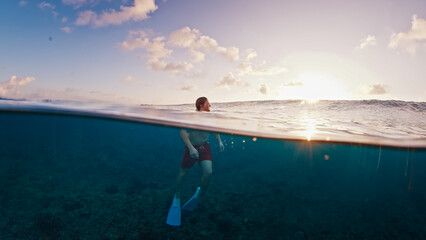 Man swims in the sea with breaking waves. Splitted shot of the male swimming in the ocean on a surfing spot