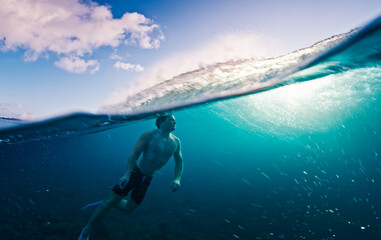 Man swims in the sea with breaking waves. Splitted shot of the male swimming in the ocean on a surfing spot
