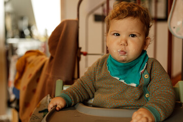 Adorable baby enjoying a meal, showcasing happy expressions and a bit of a mess.