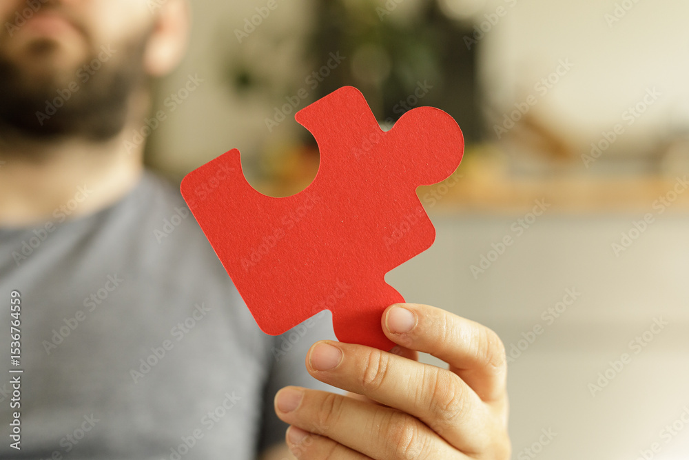 Aufkleber Close-up of a man's hand holding a red puzzle piece.  Ideal for teamwork, problem-solving, and connection concepts.
