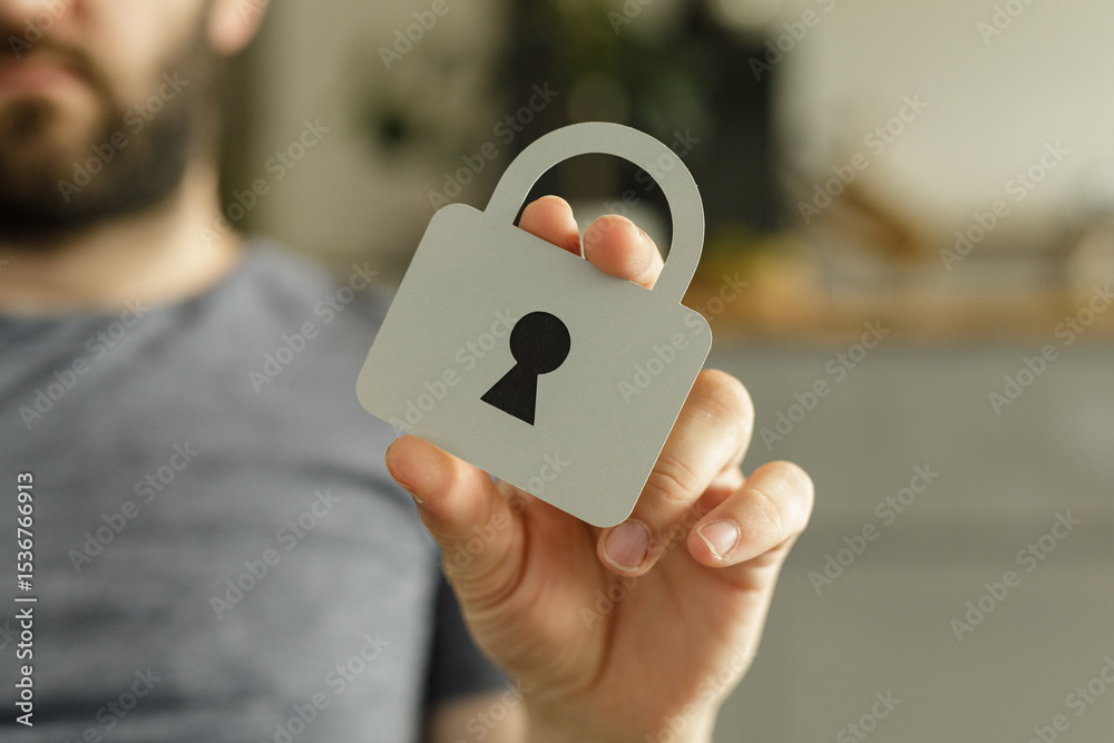 Poster close-up of a person holding a paper cutout of a padlock, symbolizing data protection and online sec