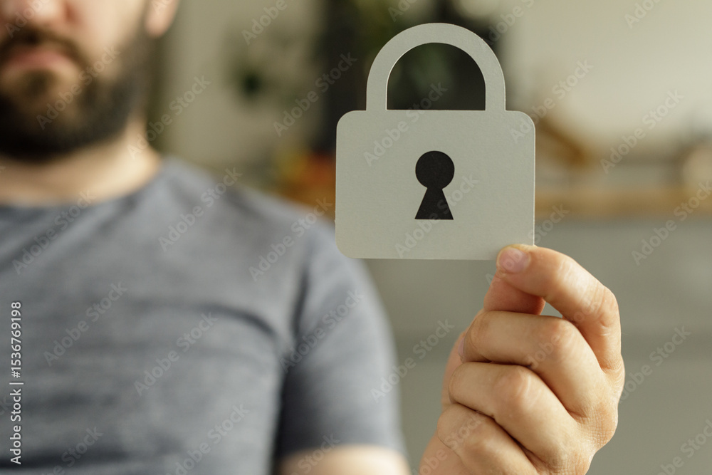 Poster stock photo of a man holding a paper cutout of a padlock, symbolizing security and data protection.
