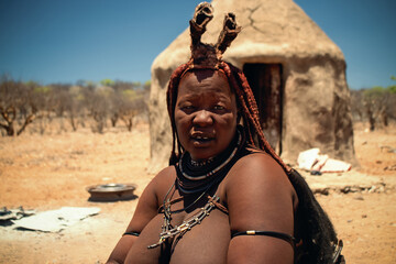 Authentic image of a Himba woman in Namibia, featuring traditional ochre body paint and handmade accessories. A real-life insight into Africa’s rich tribal culture and feminine strength.