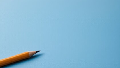 Graphite Pencil Lying on a Light Blue Background in a Simplistic Artistic Workspace Setting