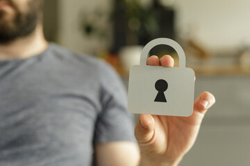Image depicting data security, privacy, and protection. A person holds a paper cutout of a padlock.