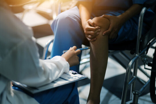 A female doctor examines an elderly patient with knee pain due to arthritis. The patient is being assisted in recovery, focusing on pain management and improving mobility.