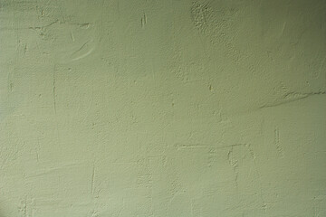 The background is a beige wall covered with paint