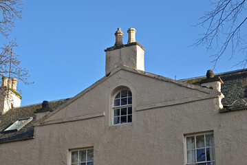 Facade Chimney and Pediment on 18th Century White Painted Building with Blue Sky 