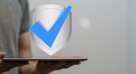 Secure your data! Image of a digital shield and checkmark on a tablet.