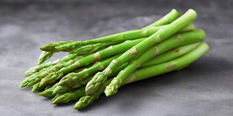 Fresh green asparagus spears on dark gray surface in close-up view