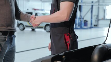 Mechanic and client shake hands in a professional setting