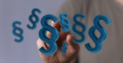Abstract image of a hand interacting with blue 3D paragraph symbols, representing law, legal,...