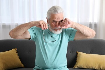 Senior man with glasses suffering from eyestrain at home