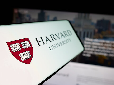 Stuttgart, Germany - 06-09-2025: Smartphone with logo of US research institution Harvard University on screen in front of website. Focus on center-left of phone display.