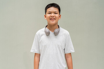 Thai Boy Portrait Against Plain Wall in Natural Light
