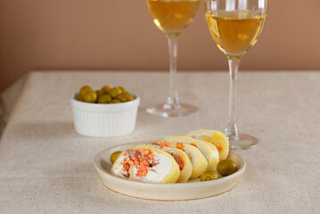 Farm cheese roll with salmon, olives and cream cheese on a table. Healthy rustic breakfast.