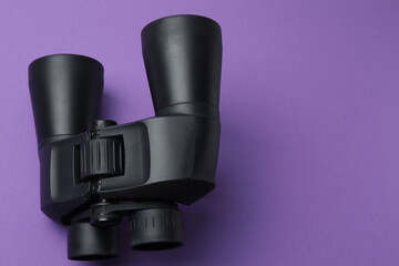 Black binoculars on background. Flat lay, top view