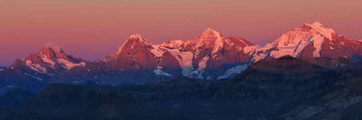 Eiger, Monch and Jungfrau in pink evening light, Switzerland.