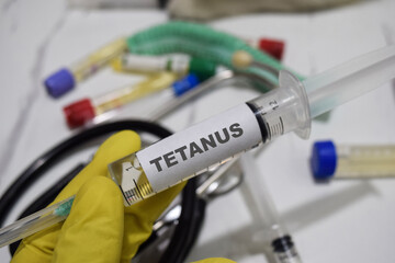 Tetanus drug syringe in yellow gloved hands. Medical concept