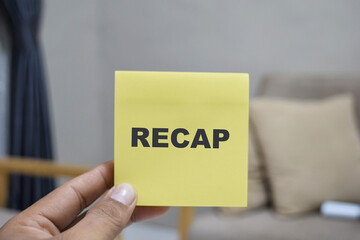 Concept of Recap write on sticky notes isolated on Wooden Table.