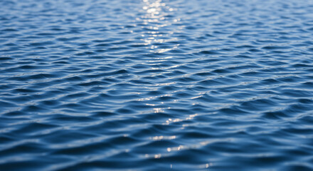 Close-up view of blue water surface with small waves and sunlight reflection