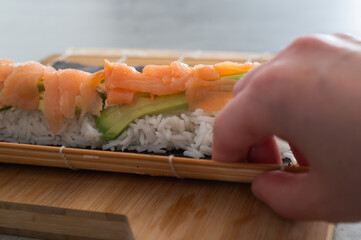 Delicious Handmade Sushi Featuring Fresh Salmon and Crisp Cucumber on a Bamboo Mat