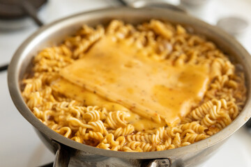 Adding cheddar cheese on pan-fried noodle ramen