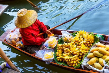 Traditional floating market in Damnoen Saduak near Bangkok in Thailand. Fruit seller at Damnoen Saduak floating market.
