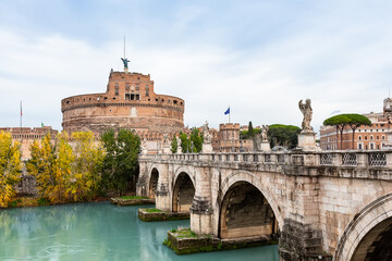 Castel Sant'Angelo and the Sant'Angelo bridge over Tiber river against cloudy sky in Rome, Italy. Castle of Holy Angel and St. Angel bridge in Rome, Italy.