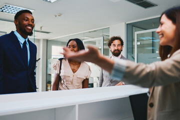 Receptionist welcoming business people entering modern office