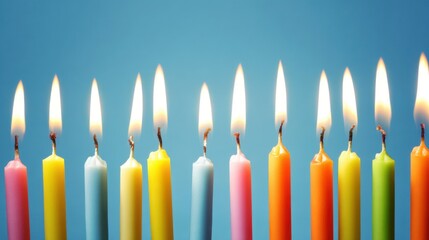 Vibrant lit birthday candles in pink, yellow, blue, orange, and green against a solid blue background with flickering flames and charred wicks, creating a festive and celebratory mood.