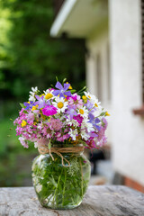 Glass vase with beautiful bouquet of summer wild flowers