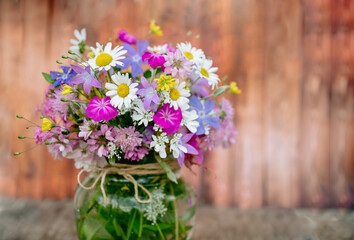 Glass vase with beautiful bouquet of summer wild flowers