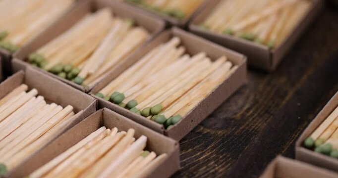 matches with green head poured into cardboard boxes , the green head of a wooden match laid out in cardboard boxes