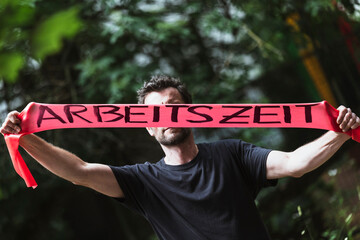 Mann stretched die Arbeitszeit mit einem Fitness Band 